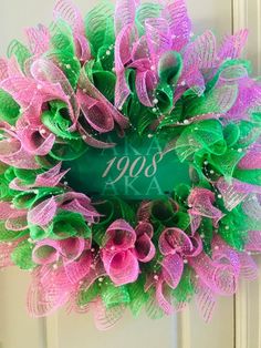 a pink and green mesh wreath with the year 2009 written on it in front of a door