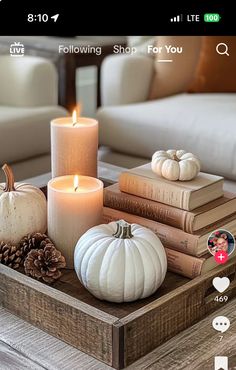 a wooden tray topped with books and candles