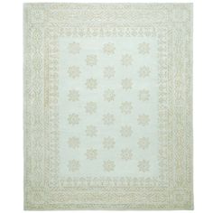 a white rug with an intricate design on the front and back side, in light green