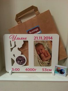 a baby's photo frame with an owl on it and a brown paper bag behind it