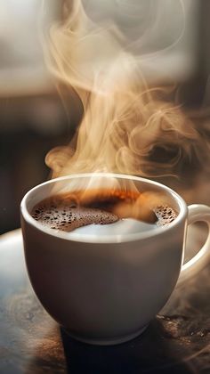 a cup of coffee with steam rising from it