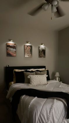 a large bed sitting in a bedroom next to two pictures on the wall above it