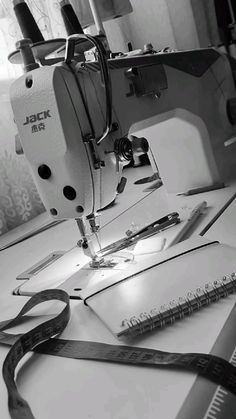 a sewing machine sitting on top of a table next to a pair of scissors and tape