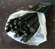 a bunch of black metal rods sitting on top of a piece of white wrapping paper