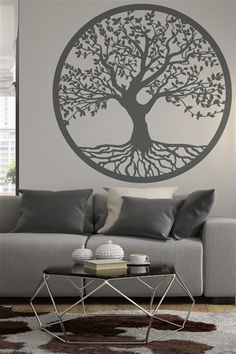 a living room with a couch, coffee table and large tree decal on the wall