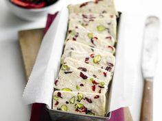 a tray filled with white chocolate covered in cranberries and pistachios