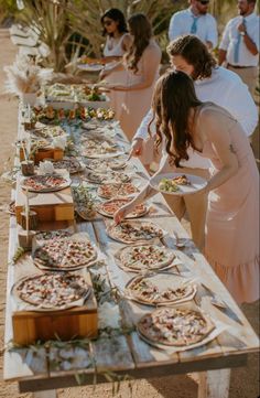 a long table filled with pizzas on top of it