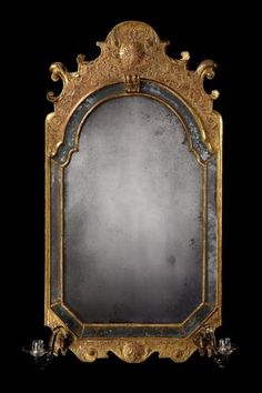 an ornate gold framed mirror against a black background