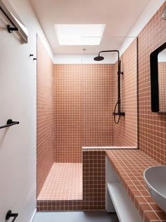 a bathroom with tiled walls and flooring next to a white sink under a mirror