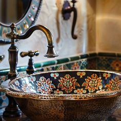 a bowl shaped sink sitting under a mirror in a bathroom next to a faucet