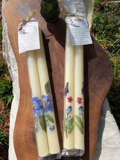 two white candles with blue flowers on them