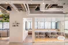 an office with glass walls and wooden flooring is seen from the entrance to the conference room