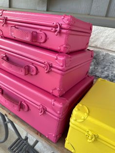 three pink and yellow suitcases are stacked on top of each other