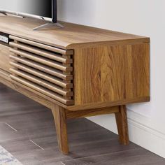 a wooden entertainment center with a flat screen tv mounted on it's sideboard