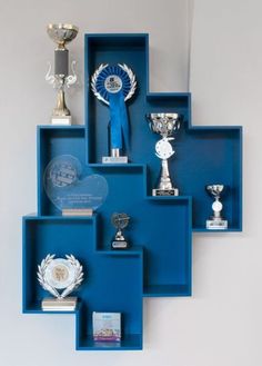 a blue shelf with several trophies on it