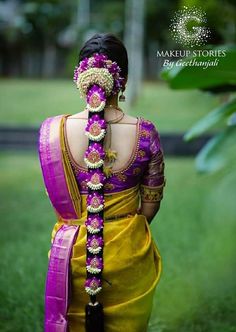 a woman wearing a yellow and purple sari with her hair in the shape of a braid