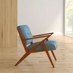 a blue chair sitting on top of a hard wood floor next to a white wall