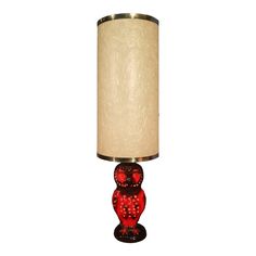 a red glass table lamp with a white shade