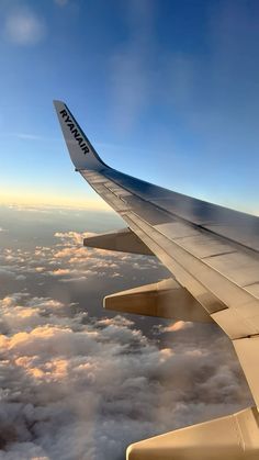 the wing of an airplane flying over clouds