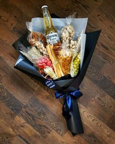 a bottle of beer sitting on top of a table next to some snacks and candies