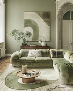 a living room with green couches and rugs on the floor, large painting in background