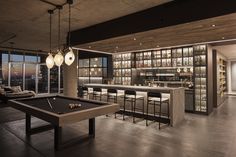 a billiard table in front of a bar with lots of bottles on the shelves