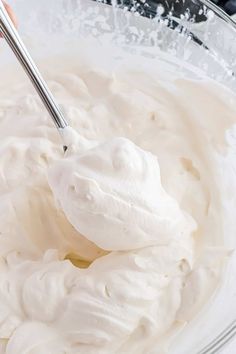 a spoon in a bowl filled with whipped cream