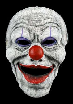 a creepy clown mask with purple eyes and red nose