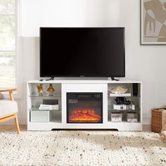 a flat screen tv sitting on top of a white entertainment center next to a fire place