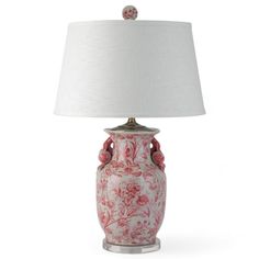 a red and white vase with a lamp on it's side, against a white background