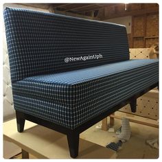 a blue and white couch sitting on top of a wooden shelf in a room filled with furniture