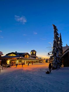 people are walking around in the snow at dusk