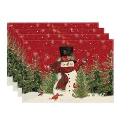 four red place mats with a snowman and birds on them in front of christmas trees