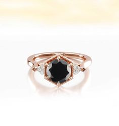 a black diamond ring with three diamonds on it's sides, set in 18k rose gold