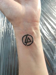 a small black and white tattoo on the wrist