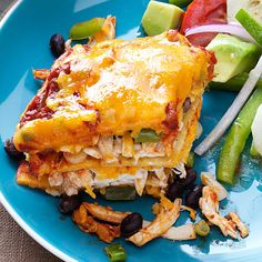 a blue plate topped with lasagna and vegetables