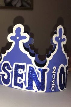 a close up of a blue crown with the word sewn on it's side