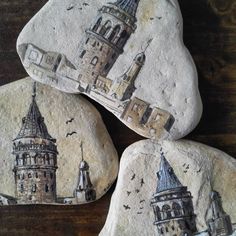 three rocks with pictures of buildings on them