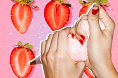 a woman's hands with red nail polish and three strawberries on pink background