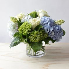 a glass vase filled with blue and white flowers