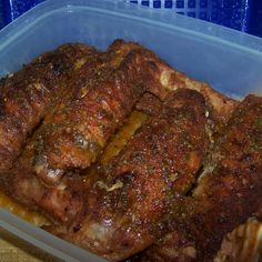 a plastic container filled with meat sitting on top of a wooden table