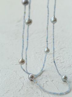 This elegant necklace features a long strand adorned with natural aquamarine and gray pearls, exuding a sophisticated charm. Perfect for adding a touch of refinement to any ensemble, it combines the serene hues of aquamarine with the timeless allure of gray pearls, creating a versatile accessory suitable for both casual and formal occasions. Metal: Recycled Sterling Silver Plated On Brass Gemstone: Aquamarine Pearl: Freshwater Pearls 9-10mm Chain Length: 1400-1450mm Weigth: 29g Silver Pearl Necklace, Handmade Jewel, Gemstone Beaded Necklace, Long Beaded Necklace, Pearl Grey, Natural Aquamarine, Elegant Necklaces, Recycled Sterling Silver, Silver Pearls