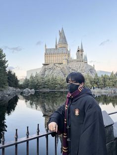 a man wearing a face mask standing in front of hogwarts castle