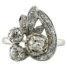 an antique diamond ring with three stones in the center and two diamonds on each side