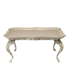 a white tray with an ornate design on the bottom and legs, sitting on top of a