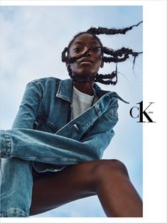 a woman with dreadlocks sitting on top of a chair in front of a blue sky