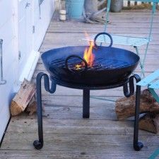 a fire pit sitting on top of a wooden deck next to a blue lawn chair