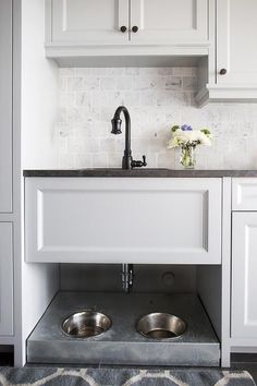 a kitchen with white cabinets and stainless steel sinks