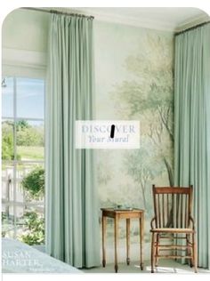 a chair and table in front of a window with curtains on the windowsills