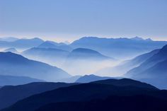 the mountains are covered in fog and light